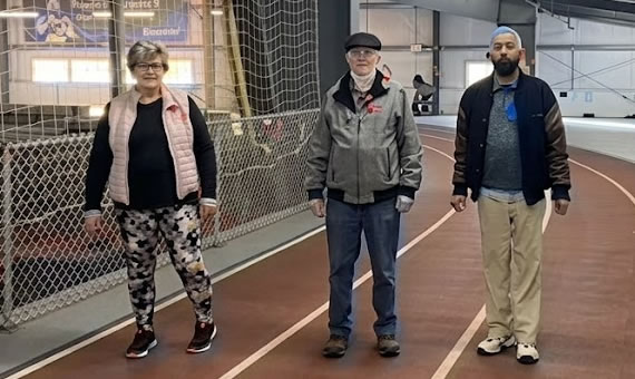 Three people walking on a track